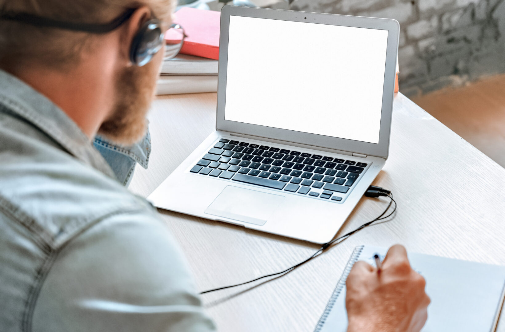Over,shoulder,close,up,man,student,wear,headphones,use,laptop